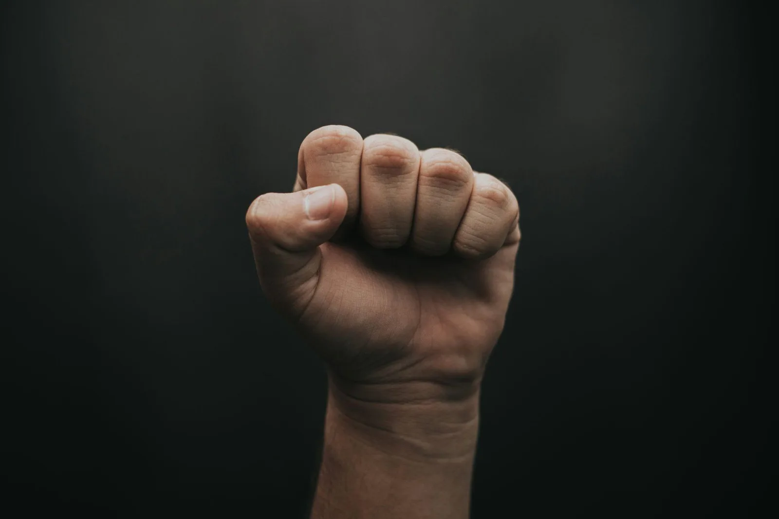 A close-up of a clenched fist against a dark background symbolizes the strength and discipline behind a bare knuckle fighting championship in Central Valley.